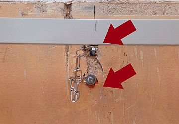 bezpečnostní ukotvení konstrukce tabule do zdi řetízkem